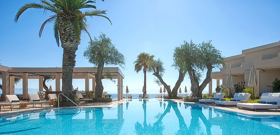 Pool mit Blick aufs Mittelmeer und Palmen im Hotel Domes Miramare, a Luxury Collection Resort in Griechenland